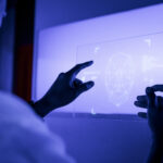 designer using a transparent digital tablet screen futuristic te